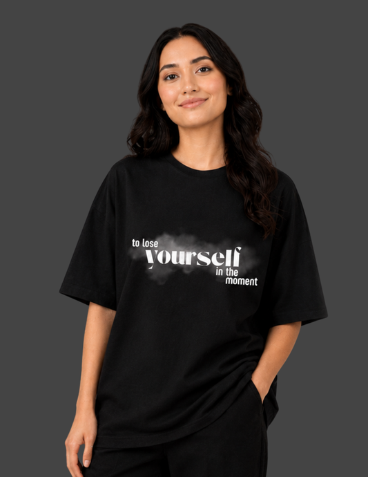 Person wearing a black t-shirt with text on a dark background