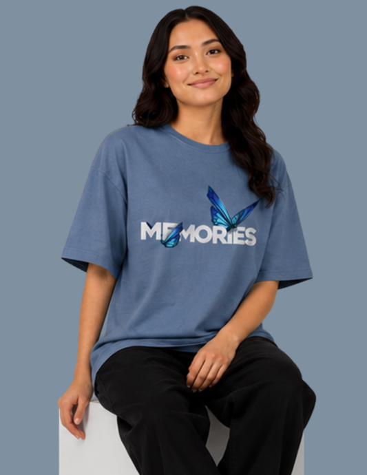 Person wearing a blue t-shirt with 'MEMORIES' and a butterfly design on a gray background