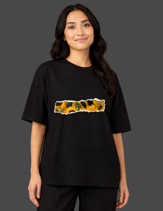 Person wearing a black t-shirt with a colorful graphic design on a dark background