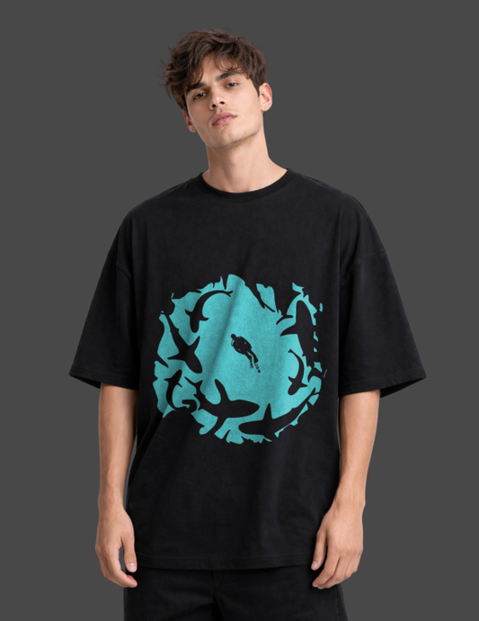 Person wearing a black t-shirt with a blue graphic design on a dark background