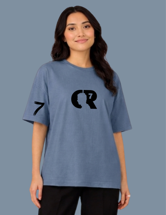 Person wearing a blue t-shirt with black graphics on a plain background