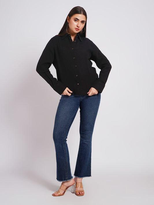 Woman wearing a black shirt and blue jeans on a white background