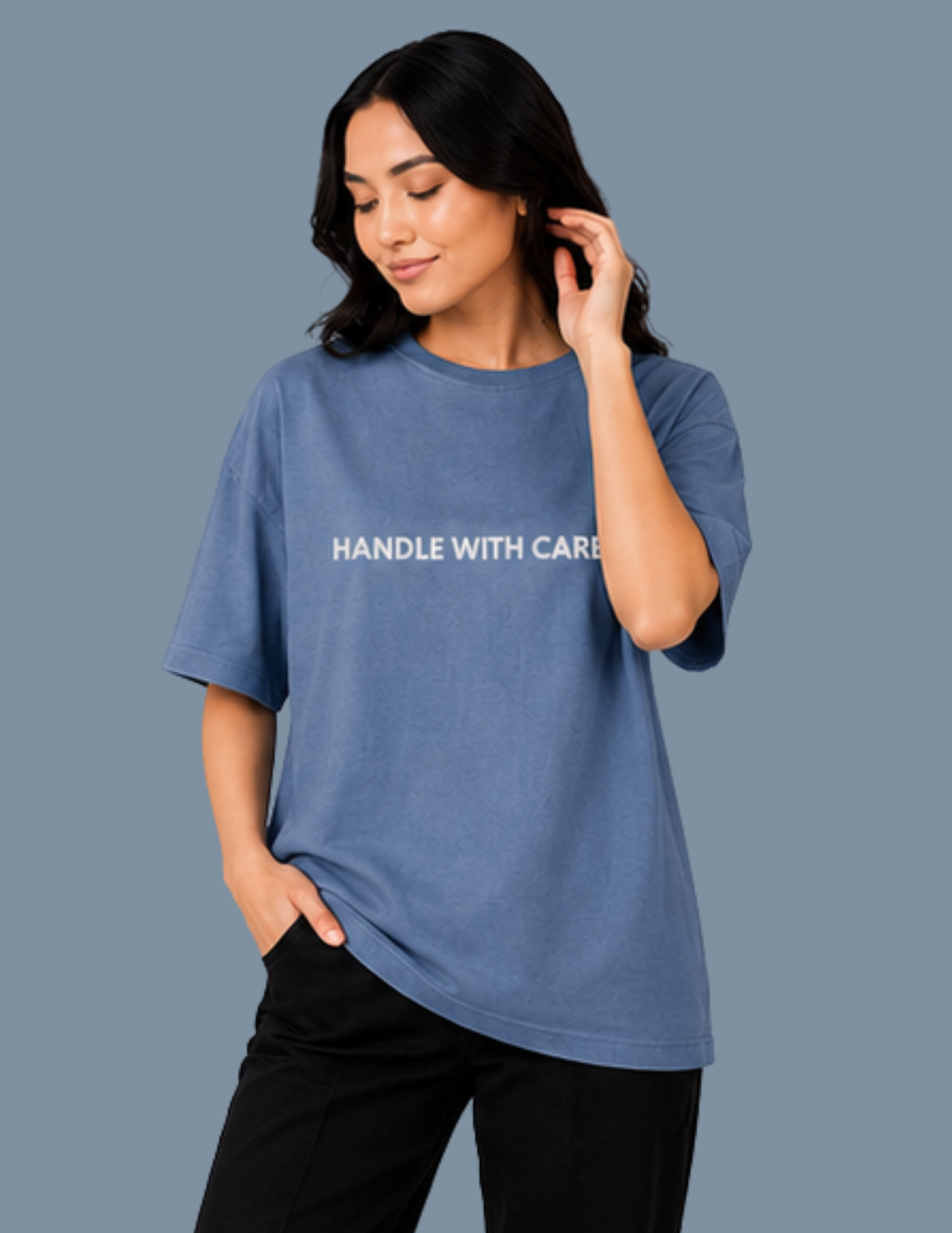 Woman wearing a blue t-shirt with 'HANDLE WITH CARE' text on a gray background