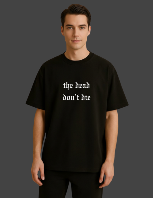 Person wearing a black t-shirt with 'the dead don't die' text on a dark background