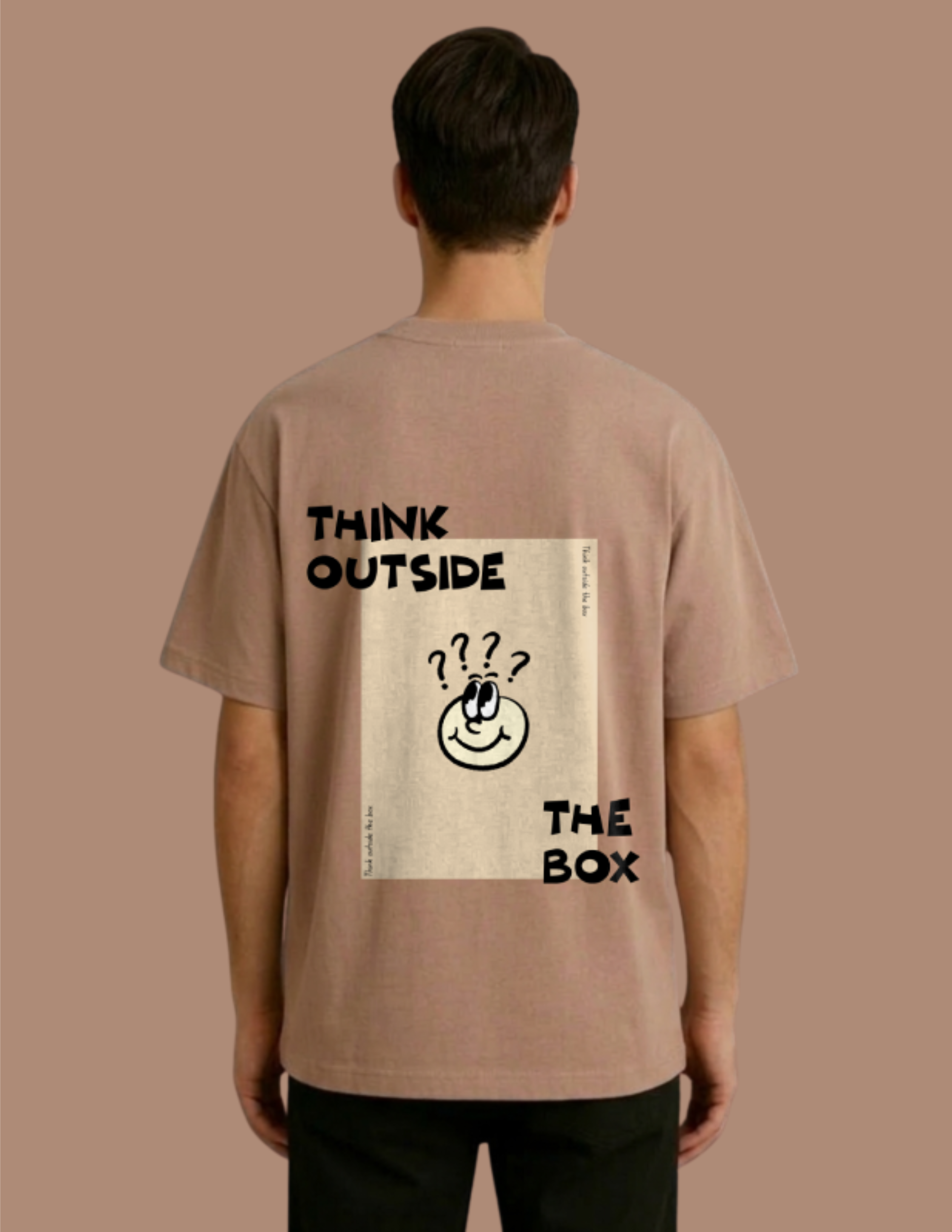 Person wearing a brown t-shirt with 'Think Outside The Box' text and graphic on the back against a beige background