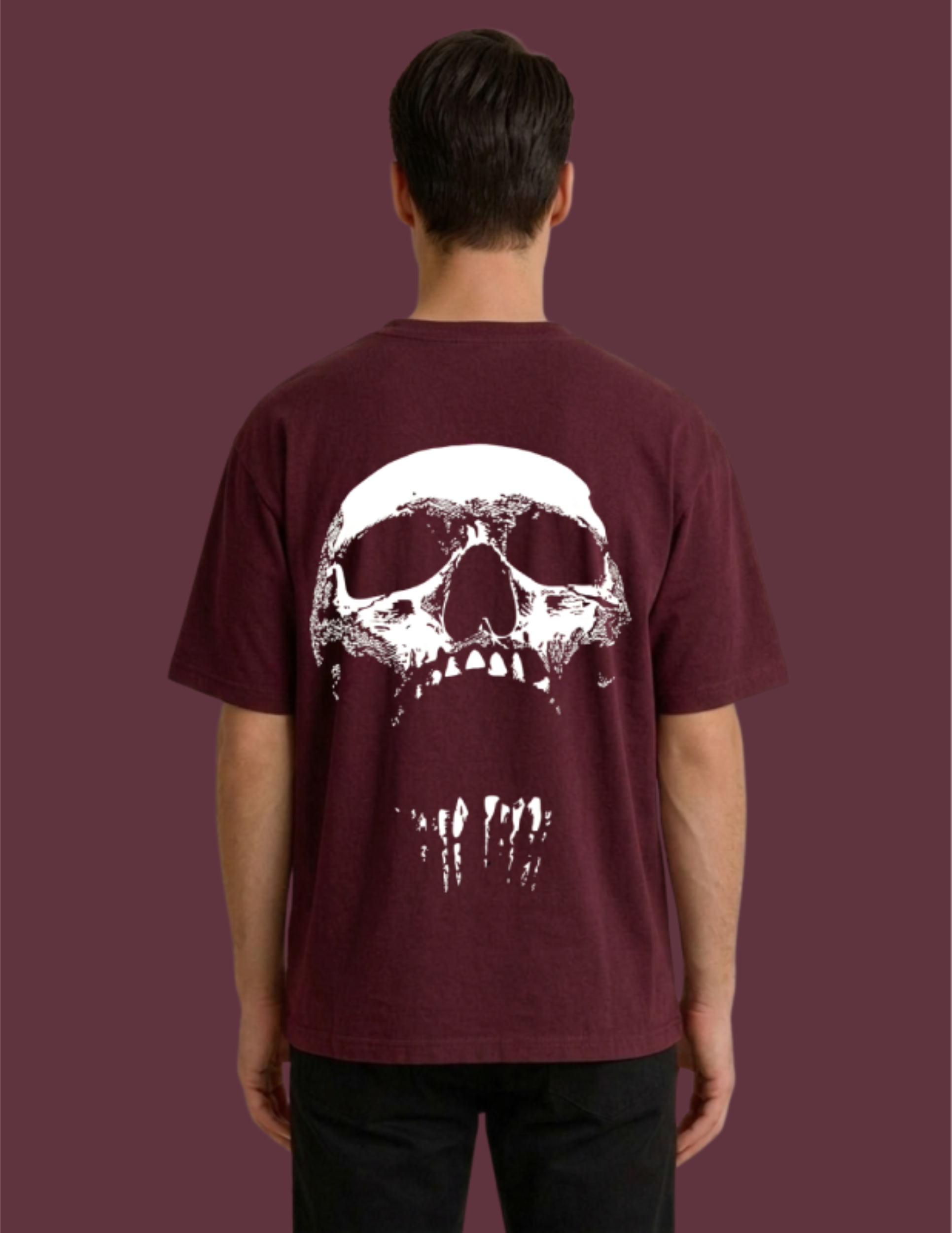Person wearing a maroon t-shirt with a white skull design on the back against a maroon background