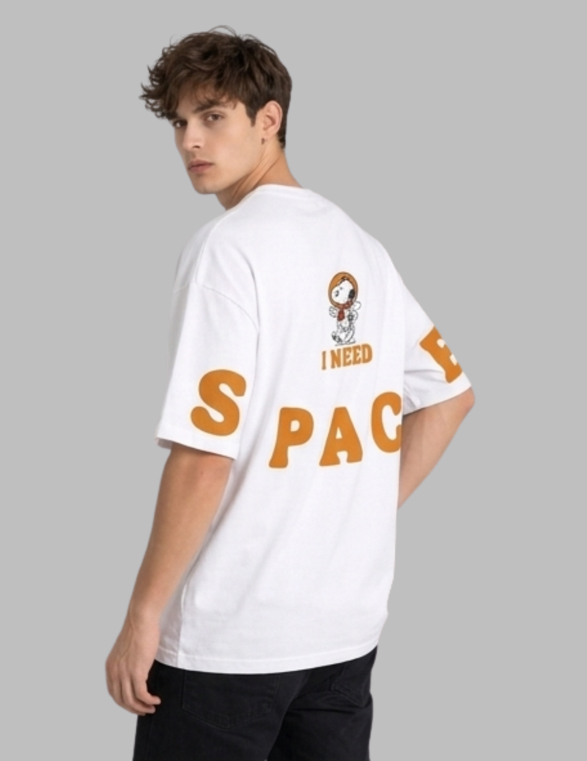 Person wearing a white t-shirt with 'I Need Space' text and Snoopy graphic on a gray background