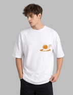Person wearing a white t-shirt with a small graphic on a gray background