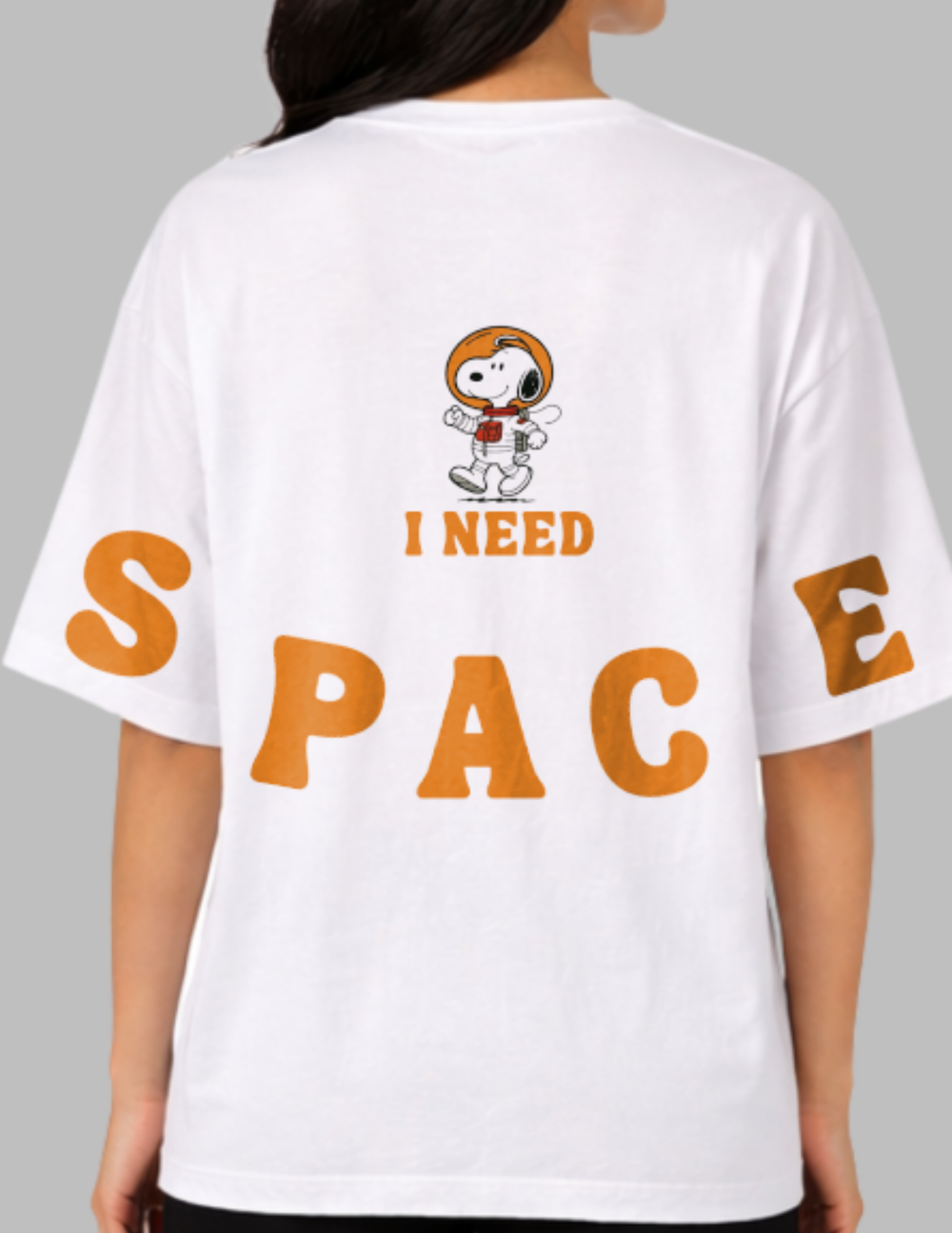 White t-shirt with a cartoon character and 'I Need Space' text on the back, worn by a person.