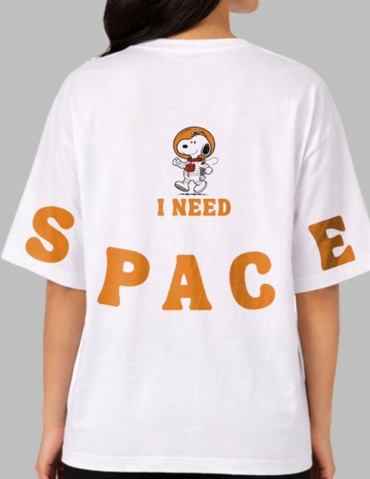 White t-shirt with a cartoon character and 'I Need Space' text on the back, worn by a person.