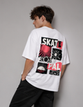 A man wearing a white t-shirt with a large graphic print on the back, featuring the words 'SKATE' and 'PAL' in black and red with sunburst and geometric designs, posed against a neutral gray background.
