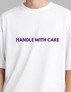 White t-shirt with 'HANDLE WITH CARE' text in purple on a gray background