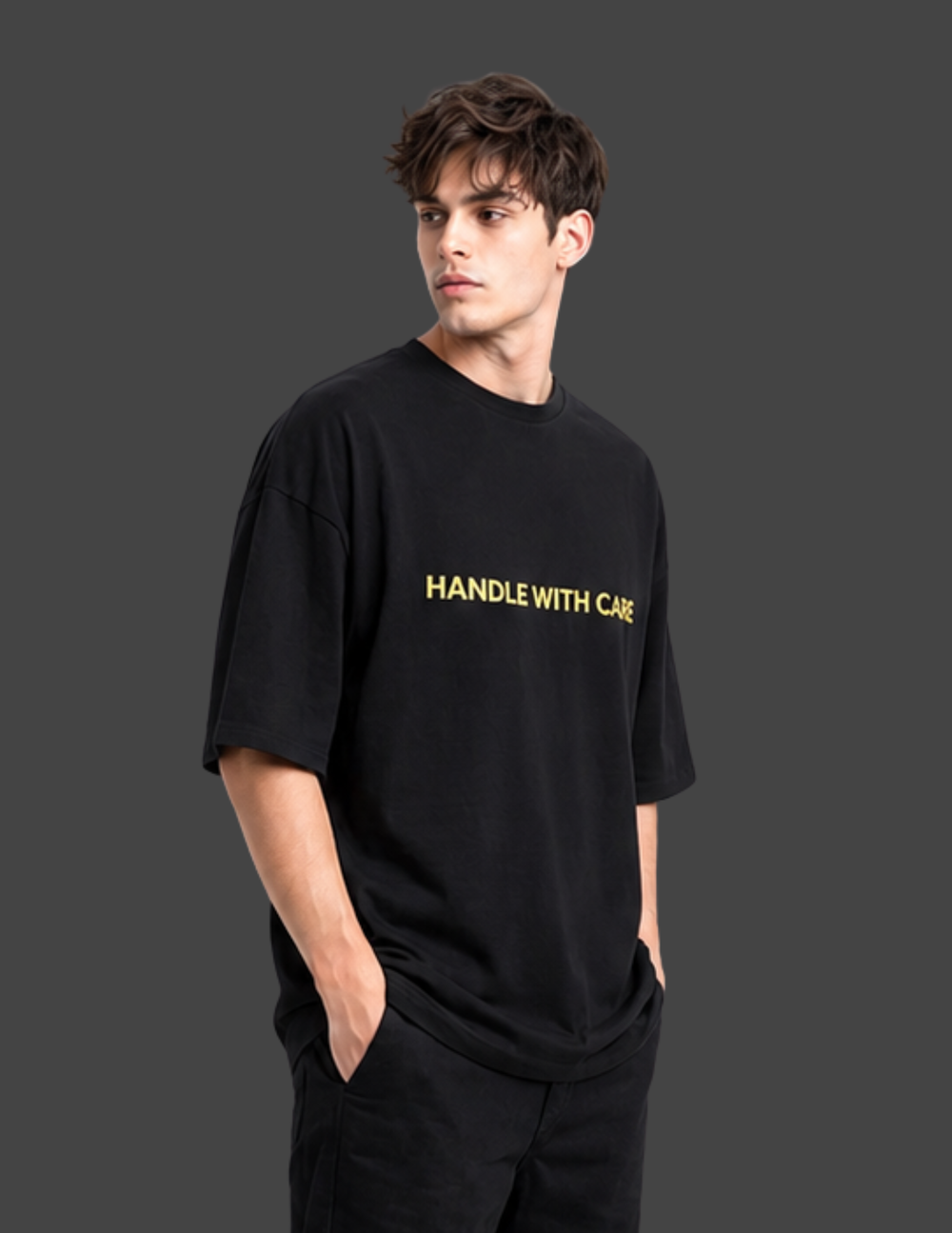 Person wearing a black t-shirt with 'HANDLE WITH CARE' text in yellow on a dark background