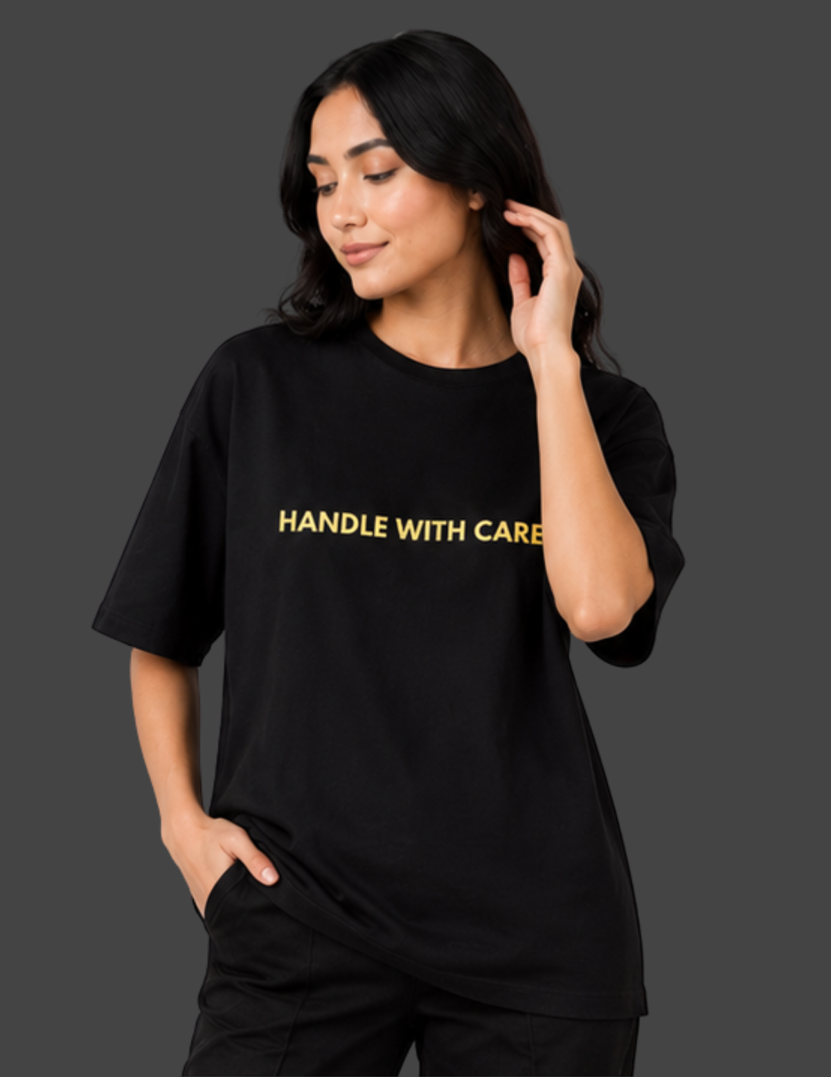 Woman wearing a black t-shirt with 'HANDLE WITH CARE' text on a dark background