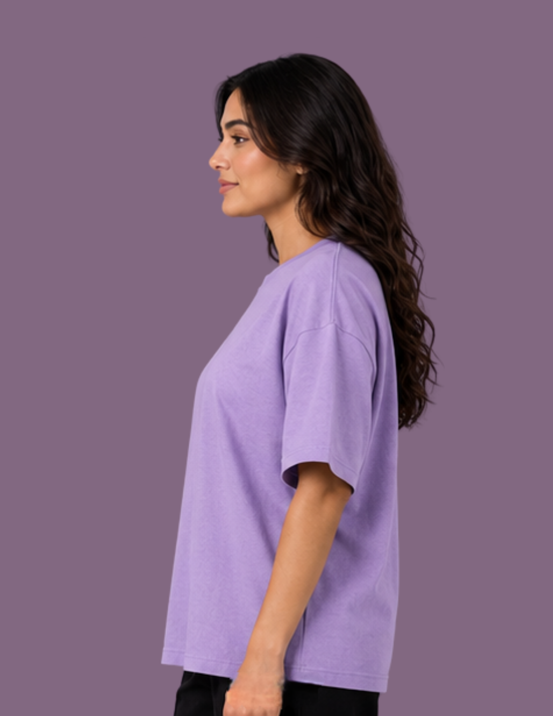 A woman shown in profile wearing an oversized short-sleeve crewneck t-shirt in light purple, set against a solid matching purple studio background.
