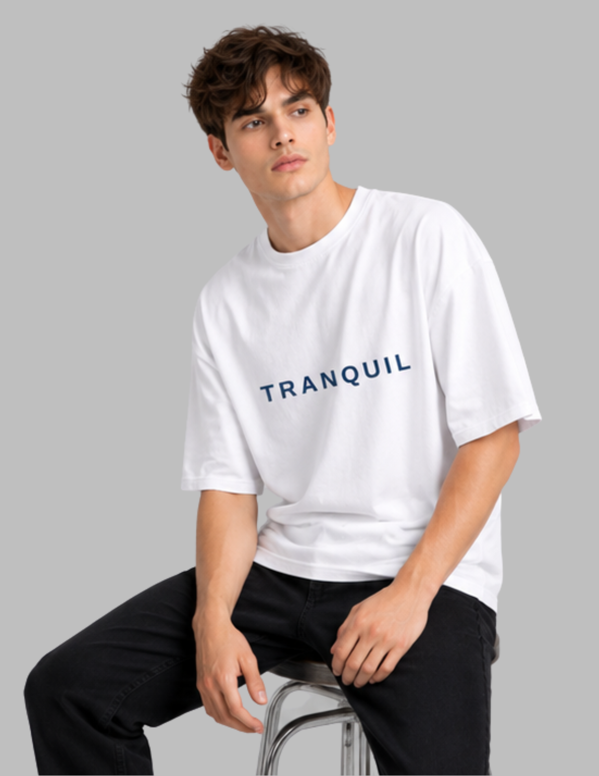 Person wearing a white t-shirt with 'TRANQUIL' text on a gray background
