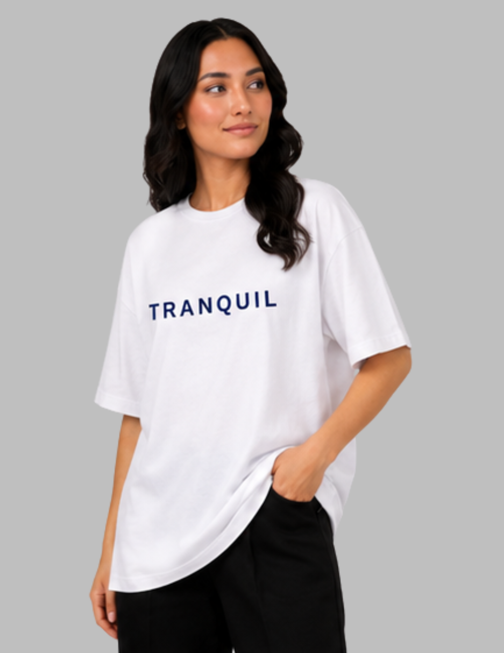 Woman wearing a white t-shirt with 'TRANQUIL' text on a gray background