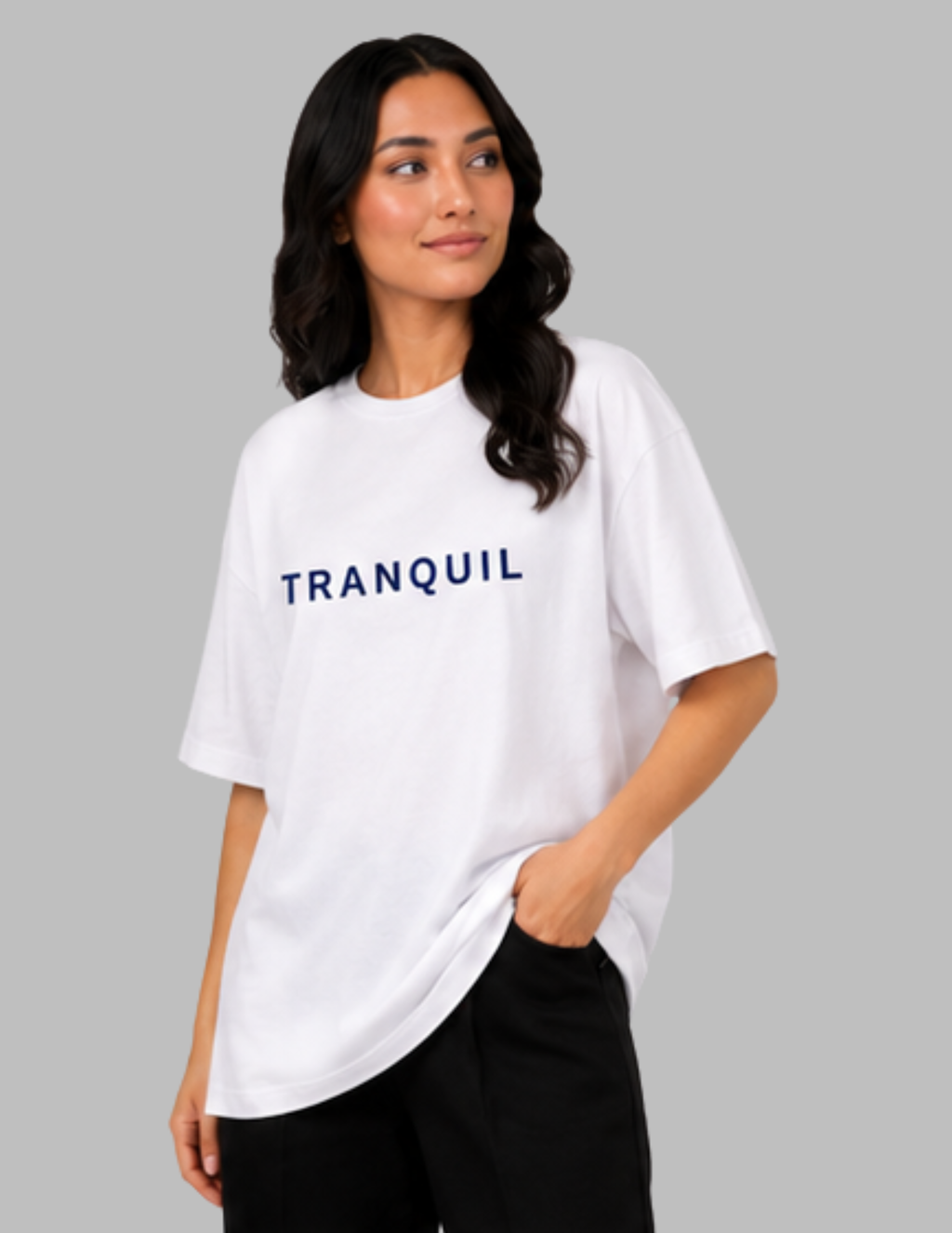 Woman wearing a white t-shirt with 'TRANQUIL' text on a gray background