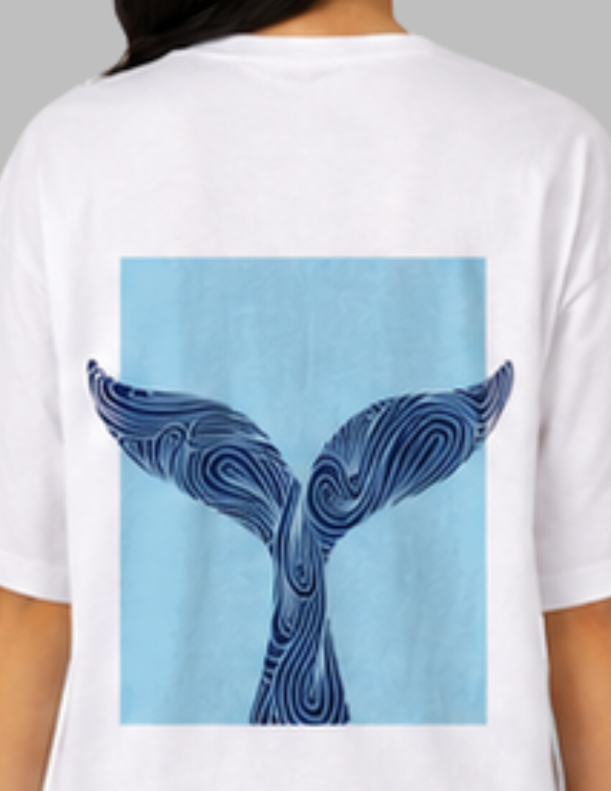 White t-shirt with a blue whale tail design on the back, worn by a person.
