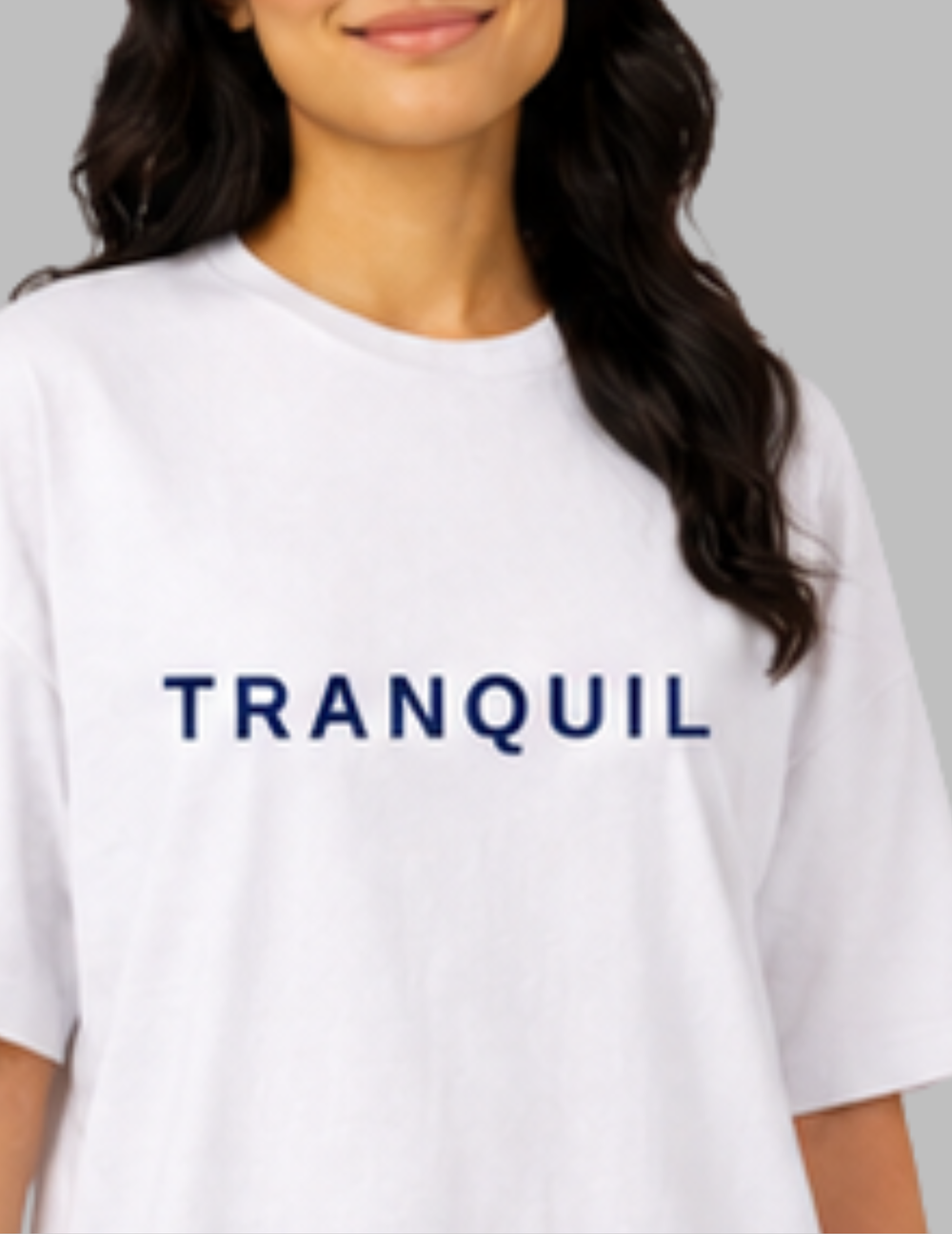 Person wearing a white t-shirt with 'TRANQUIL' text on a gray background