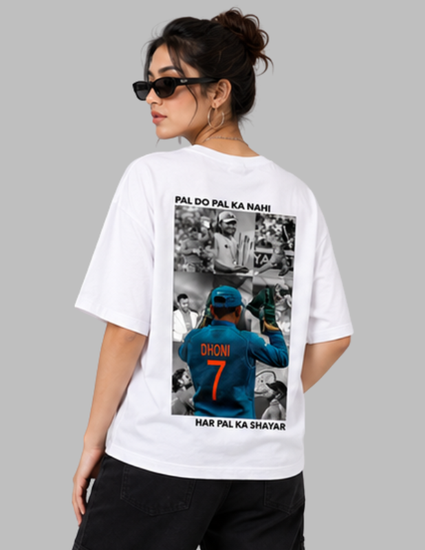 A woman modeling a white graphic t-shirt from the back, featuring a large print of Indian cricket player Dhoni in a blue jersey with the number 7, surrounded by black-and-white photos and the text 'PAL DO PAL KA NAHI' and 'HAR PAL KA SHAYAR'.