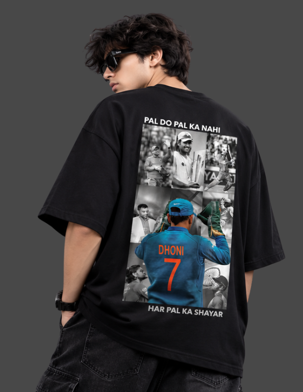 A man wearing a black oversized t-shirt from the back, featuring a large graphic print of cricket player Dhoni with the text 'PAL DO PAL KA NAHI! HAR PAL KA SHAYAR'.