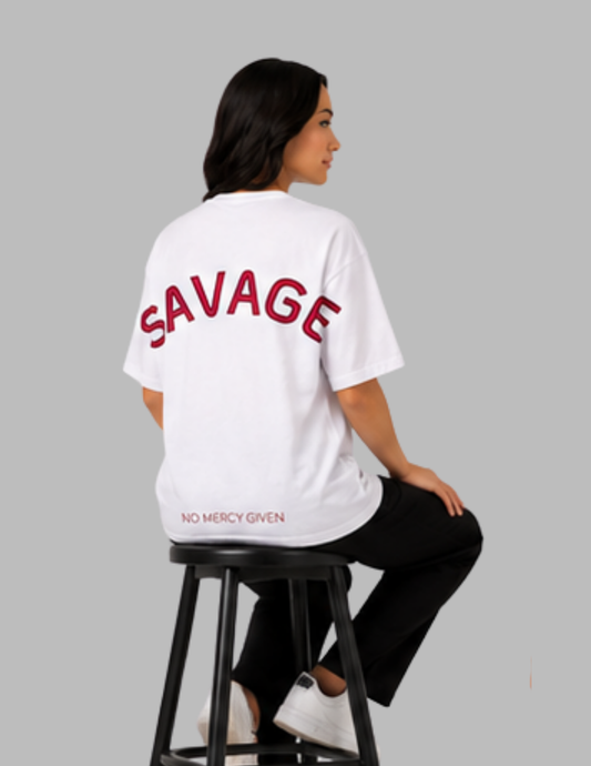Person wearing a white t-shirt with 'SAVAGE' printed on the back, sitting on a black stool against a gray background.