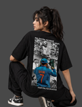 A model wearing a black oversized t-shirt with a large back graphic of Indian cricketer Pal Dhawan, posed against a dark gray studio background.
