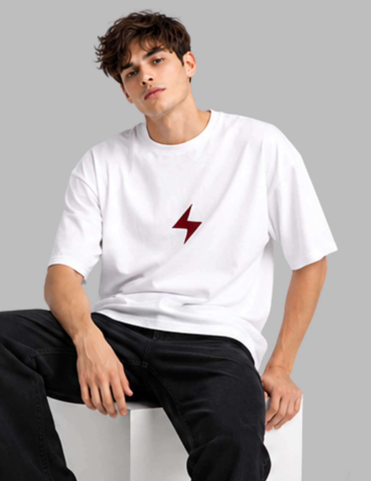 Person wearing a white t-shirt with a red lightning bolt design on a gray background
