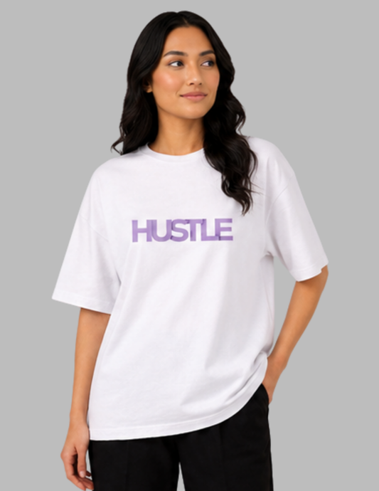 Woman wearing a white t-shirt with 'HUSTLE' in purple on a gray background