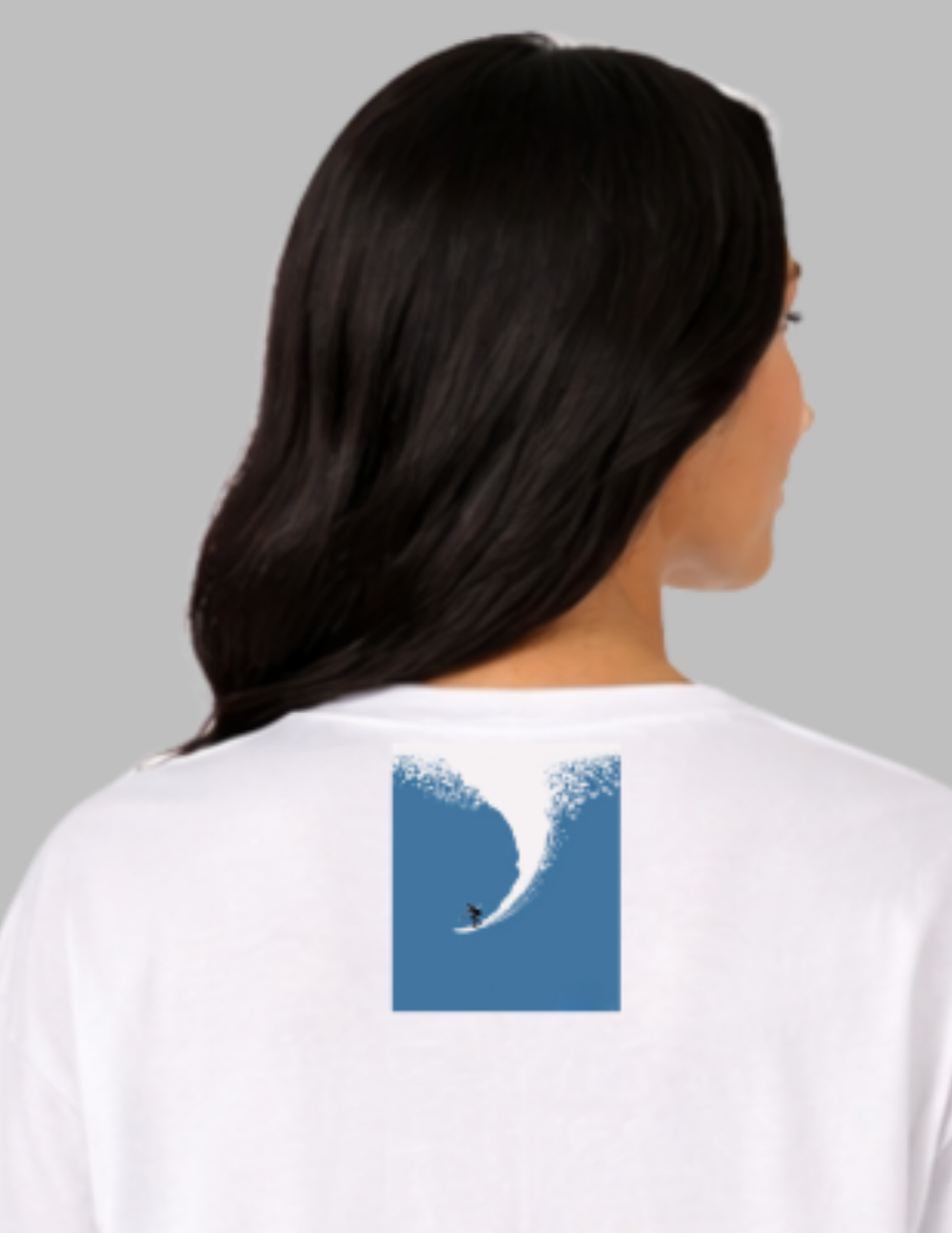 Person wearing a white t-shirt with a blue wave design on the back against a gray background