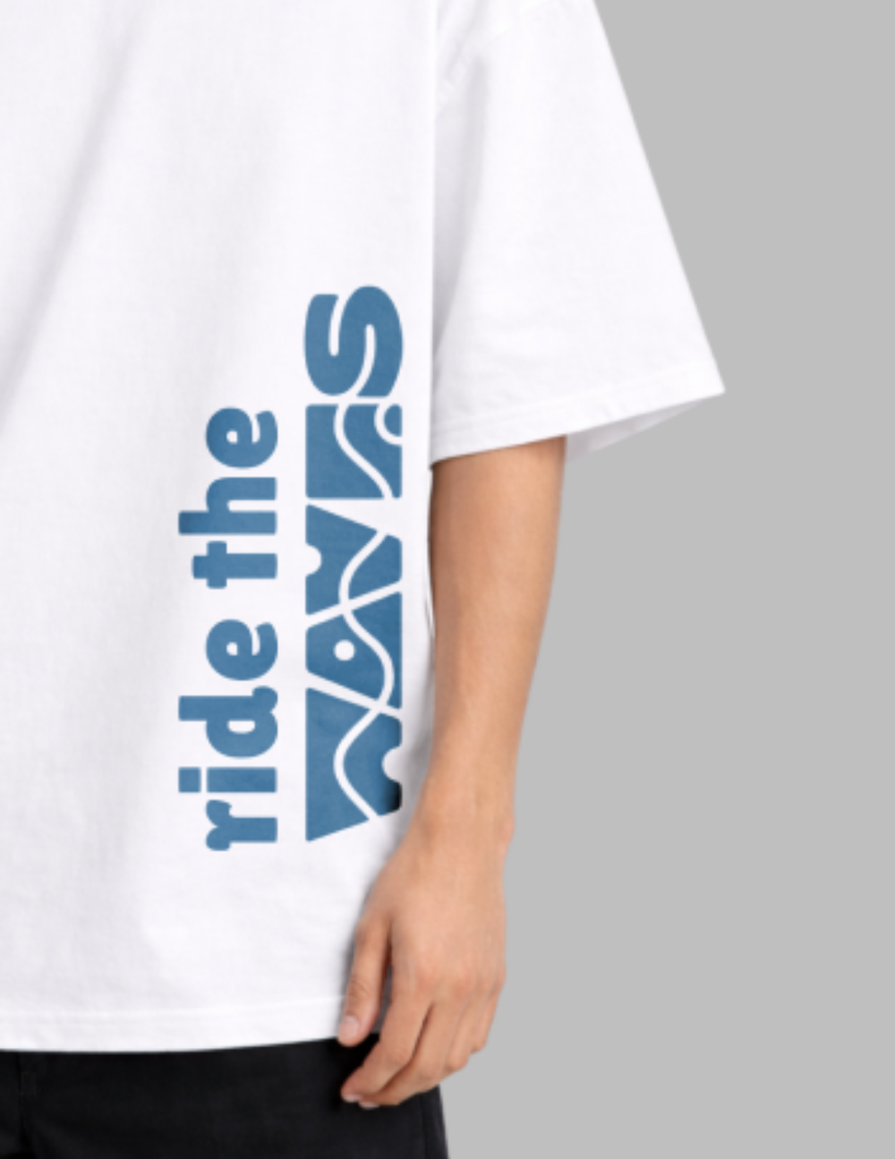 White t-shirt with blue text 'ride the waves' on a gray background