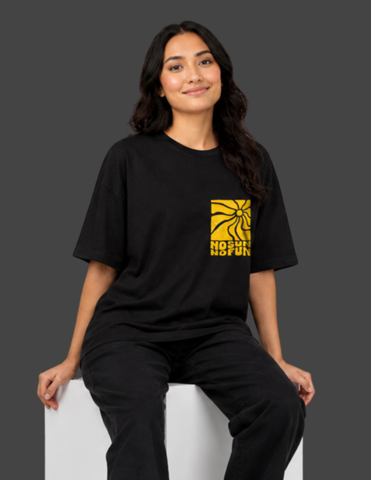 Person wearing a black t-shirt with a yellow logo on a gray background