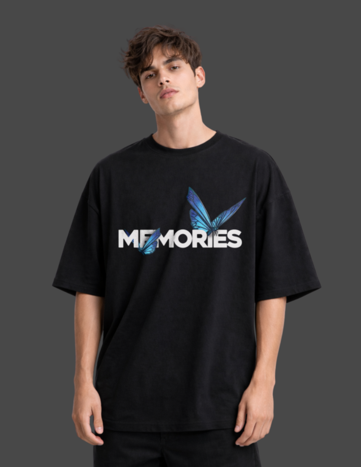 Person wearing a black t-shirt with 'MEMORIES' design on a dark background