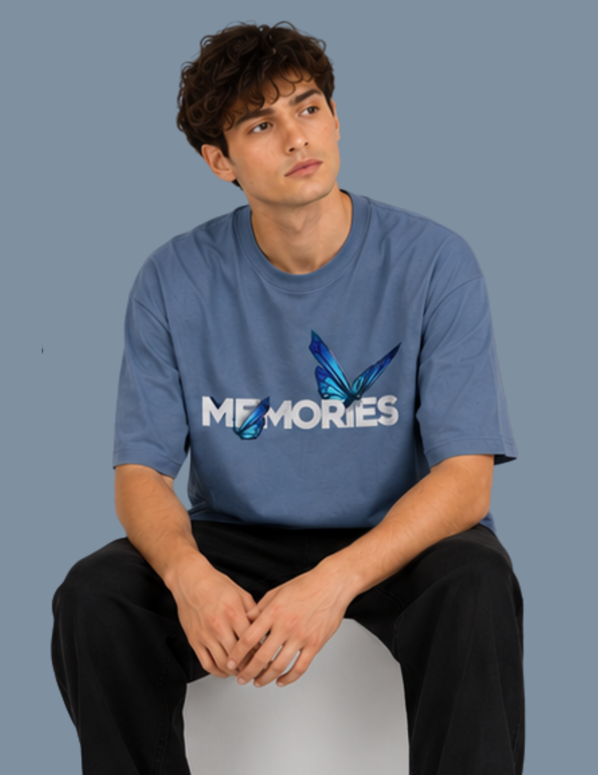 Person wearing a blue t-shirt with 'MEMORIES' design on a plain background