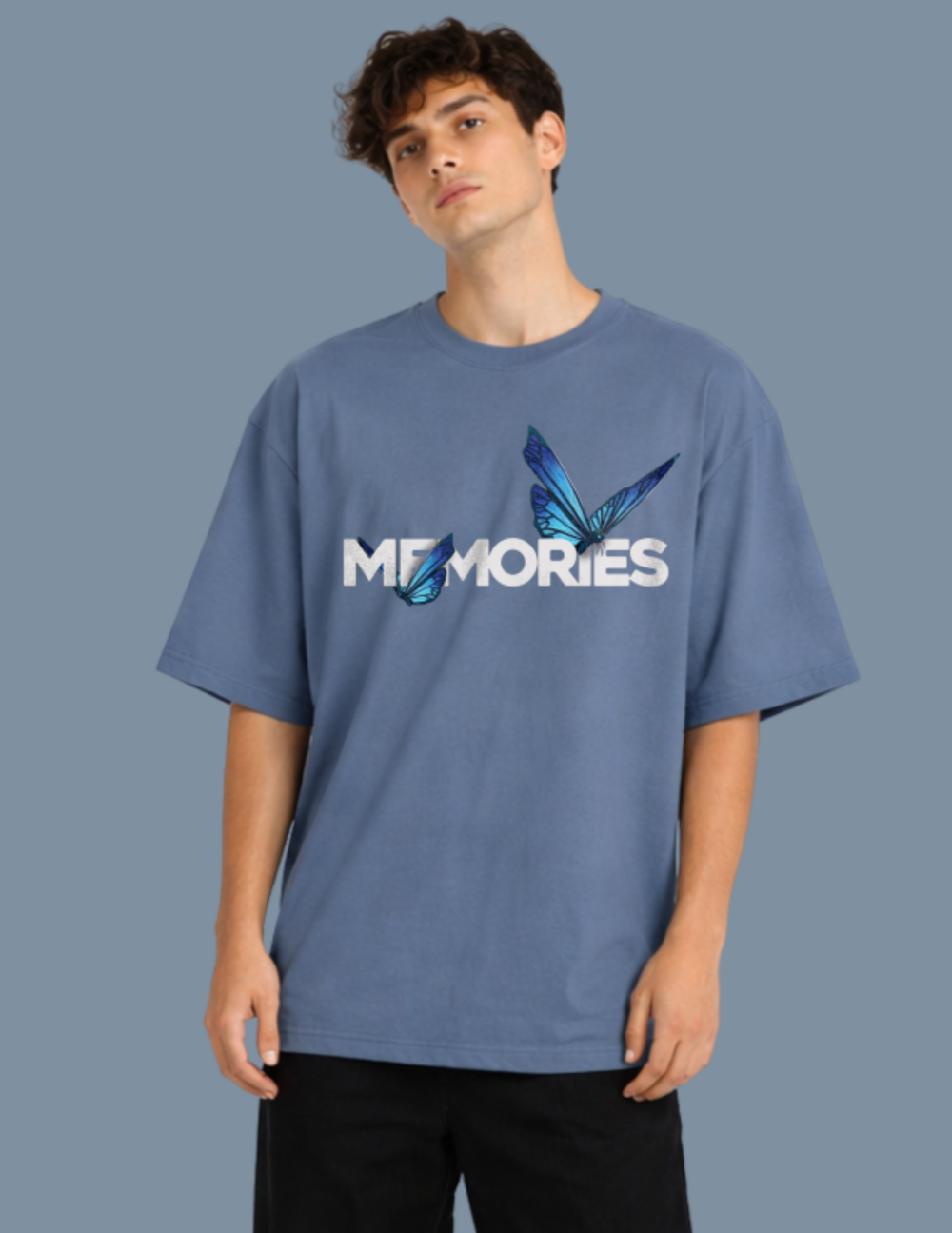 Person wearing a blue t-shirt with 'MEMORIES' and butterfly graphics on a gray background