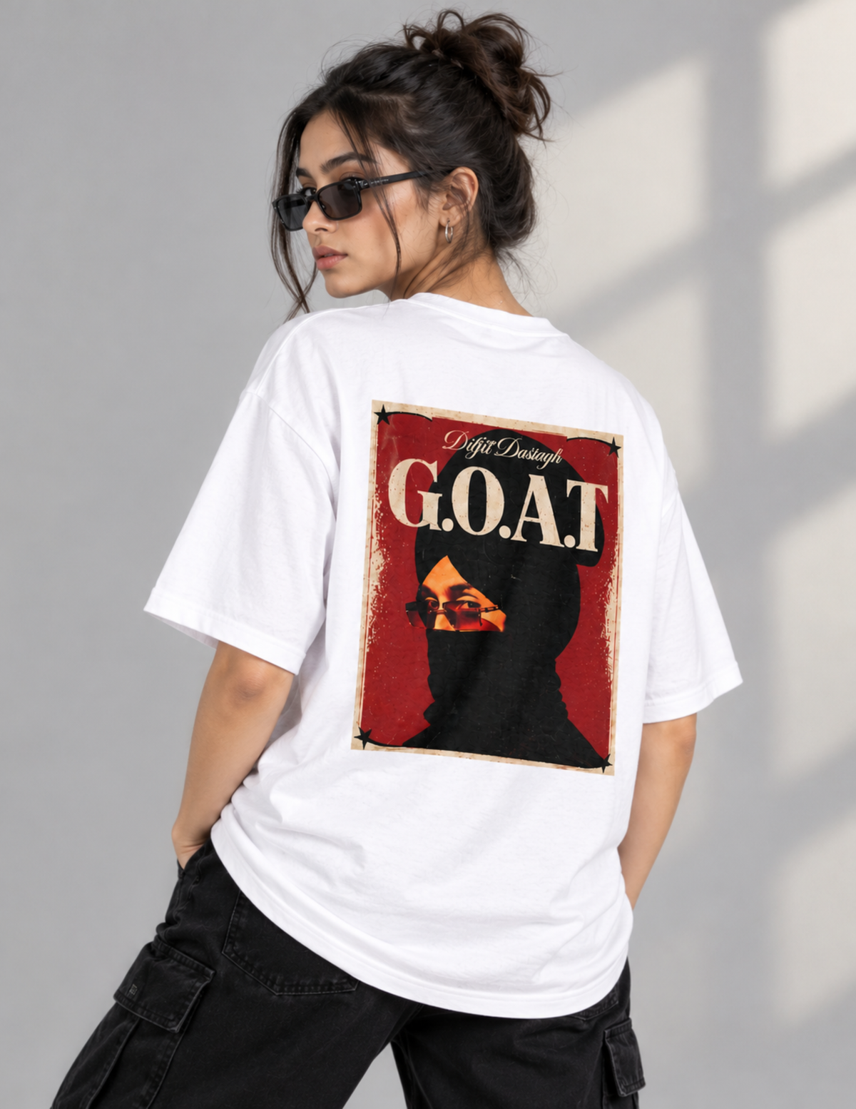 A woman wearing a white oversized T-shirt with a large back graphic that reads 'G.O.