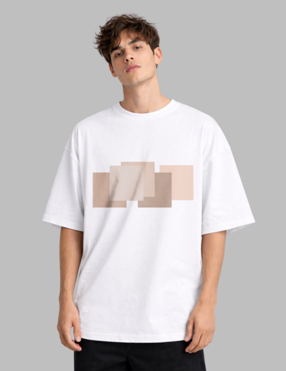 Man wearing a white t-shirt with a beige geometric design on a gray background