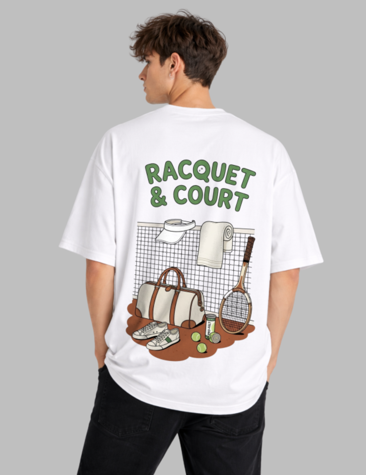 A man wearing a white oversized t-shirt from the back, featuring a green and brown graphic design with the text 'RACQUET & COURT' and illustrations of tennis gear, set against a solid gray background.