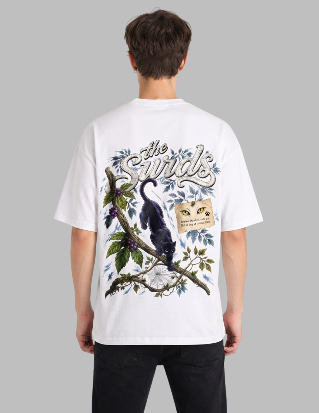 A man viewed from behind wearing a white graphic t-shirt with a detailed illustration of a black bird on a branch with blue leaves and the text 'the Bird'.