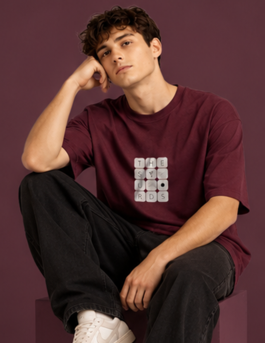 Play with words, wear your identity. The Surds Scrabble-inspired oversized T-shirt features a minimal tile-style graphic spelling out the brand name on a classic black base. Designed for a clean, effortless streetwear look.