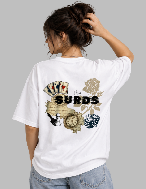 A woman shown from behind wearing a white oversized T-shirt with a large vintage-style graphic on the back featuring playing cards, a rose, a clock, dice, and the text 'the SURDS'.