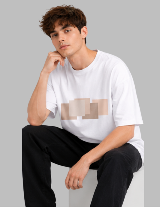 Man wearing a white t-shirt with a geometric design sitting against a gray background