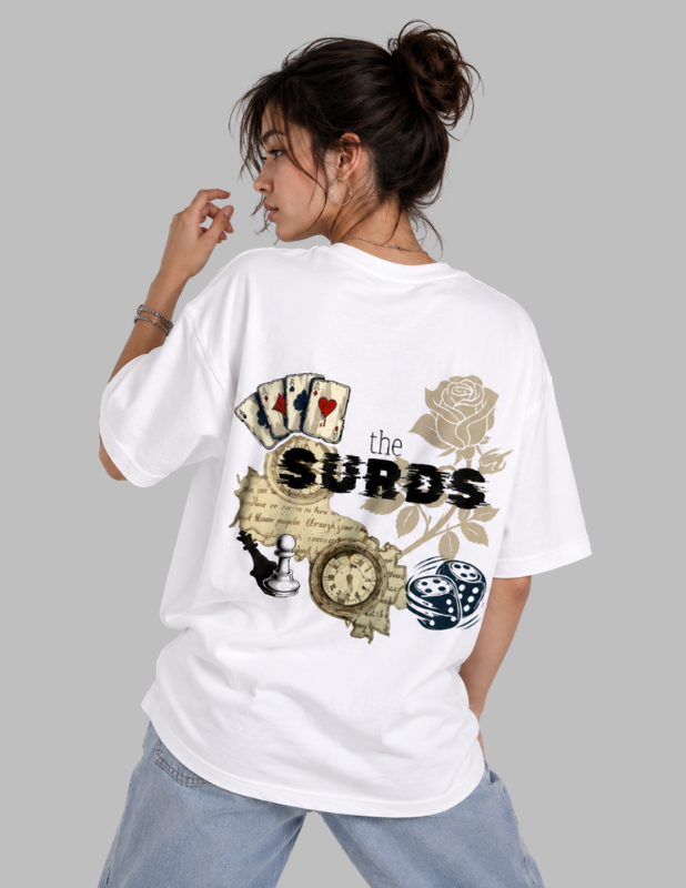 A woman wearing an oversized white graphic T-shirt from the back, featuring a vintage-style design with playing cards, a rose, a clock, dice, and the text 'the SURODS'. She is paired with light blue jeans against a solid gray studio background.