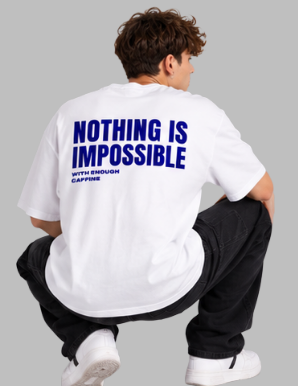 A man wearing a white t-shirt with bold blue text on the back reading 'NOTHING IS IMPOSSIBLE WITH ENOUGH CAFFEINE', paired with black pants and white sneakers, shown from behind against a solid gray background.
