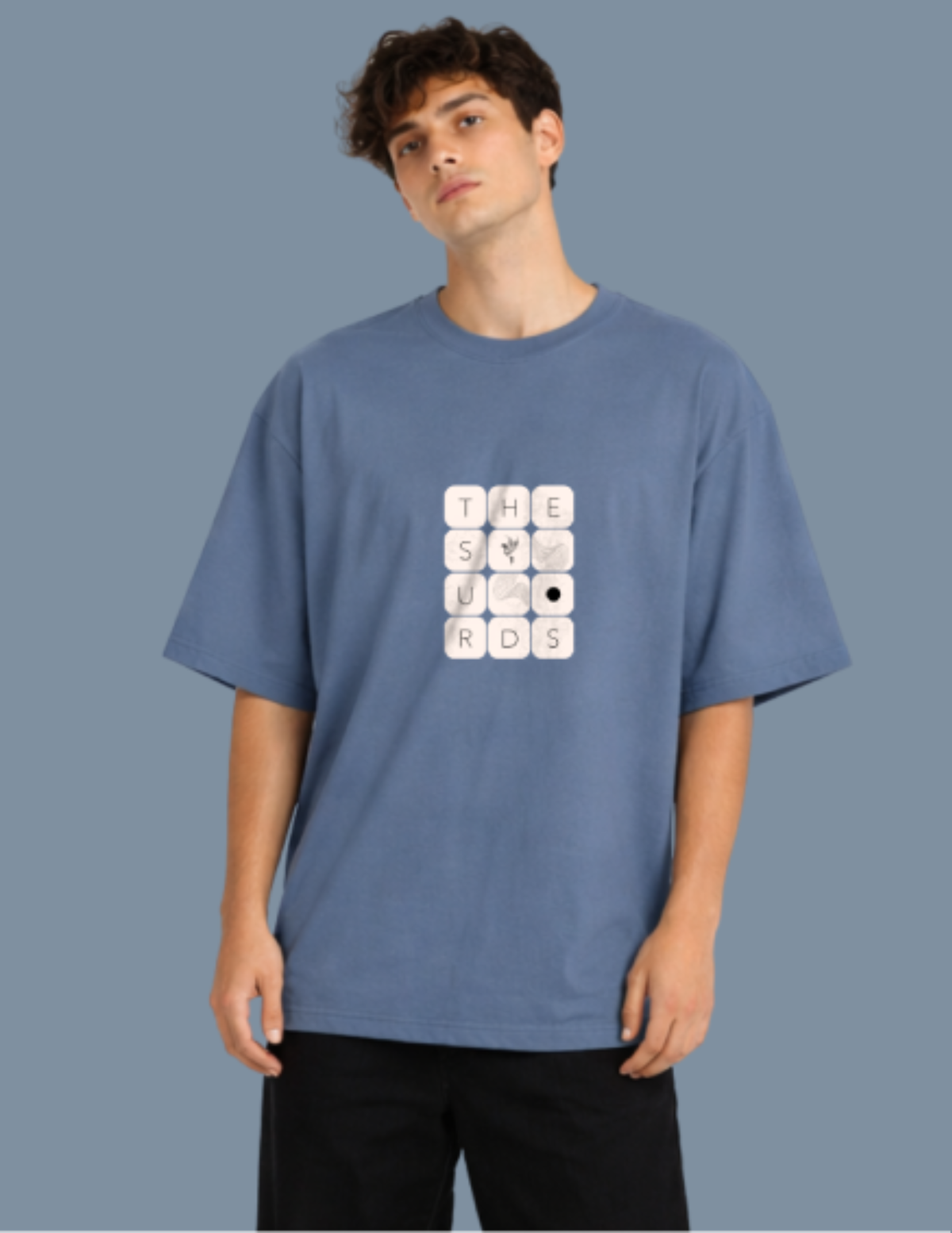 Play with words, wear your identity. The Surds Scrabble-inspired oversized T-shirt features a minimal tile-style graphic spelling out the brand name on a classic black base. Designed for a clean, effortless streetwear look.