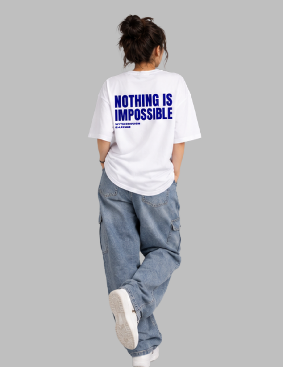 A model shown from behind wearing a white t-shirt with bold blue text reading 'NOTHING IS IMPOSSIBLE' on the back, paired with light blue cargo pants and white sneakers, set against a solid gray background.