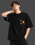 A man wearing a black oversized t-shirt with a graphic of a flying bald eagle on the left chest and white text on the right sleeve, posed against a dark gray studio background.