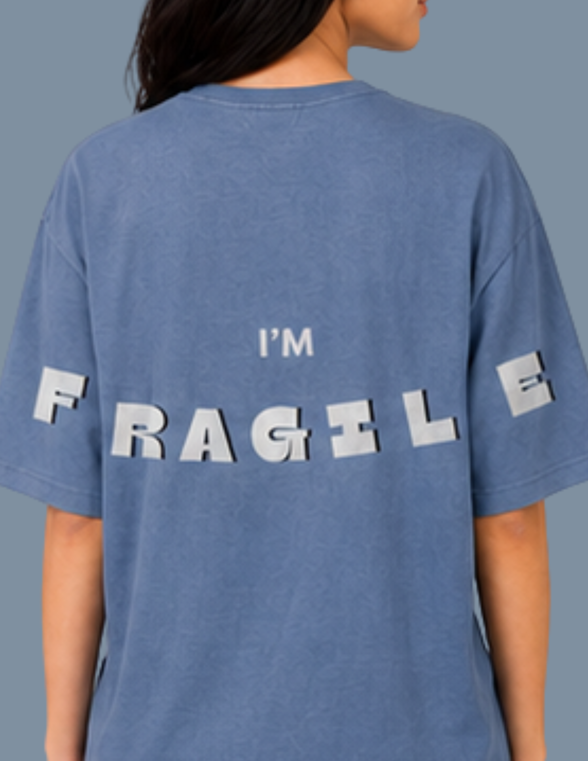 Blue t-shirt with 'I'm Fragile' text on the back, worn by a person.