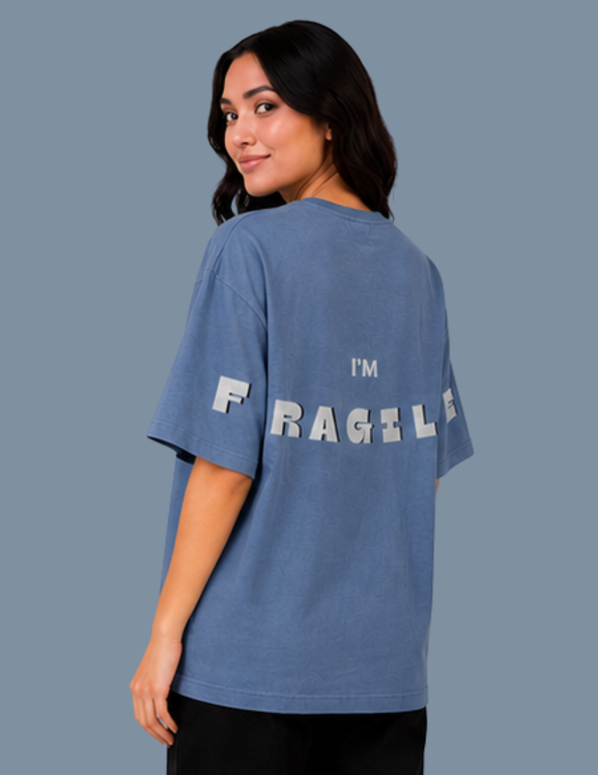 Person wearing a blue t-shirt with 'I'm Fragile' text on the back against a gray background